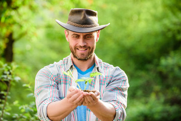 Sticker - successful farmer hold plant in ground in hands. farming and agriculture cultivation. Gardening. Eco farm worker. Earth day. happy earth day. Eco living. muscular ranch man in cowboy hat care plants.