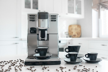 Coffee machine with cups for espresso on the kitchen table. Close-up