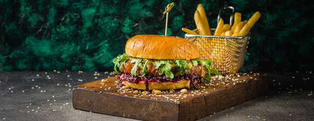 Hamburgers and French fries on the wooden tray.