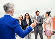 © Halfpoint - A group of joyful businesspeople having a party outdoors on roof terrace in city.