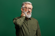 © the faces - handsome stylish senior man with closed eyes in green shirt suffers from neckache. old man has problem with neck. close up photo, health care