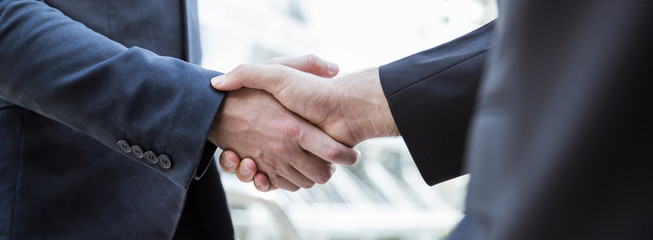 Closeup business caucasian man shaking hands in city. Teamwork friendship businessman entrepreneur partnership  greeting brainstorm winning success synergy communication agreement concept banner