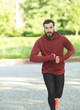© lashkhidzetim - Running man jogging in city street park at beautiful summer day. Sport fitness model caucasian ethnicity training outdoor.