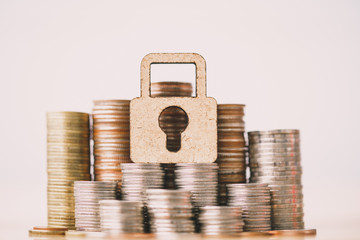 Wooden lock and stack of coins in concept of savings and money growing or energy save. Business investment growth concept. money saving and Investment. retirement concept. Risk management concept.