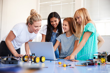 Wall Mural - Three Female Students With Teacher Building Robot Vehicle In After School Computer Coding Class