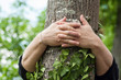 © pixarno - closeup of woman hugging a tree trunk in a forest