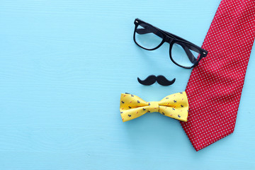 Wall Mural - Father's day concept. Necktie and mustache over wooden background. top view, flat lay