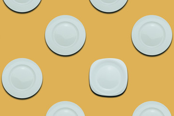 Poster - White round plates and one different plate on a yellow flat background. Copy space