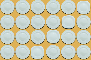 Poster - White round plates and one different plate on a yellow flat background. Copy space