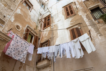 Patio interior de casas antiguas y decadentes, con ropa tendida, en un pueblo de la región de Puglia  en Italia