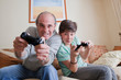 © REB Images/Tetra Images - Father and teenage son playing video game