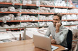 © mavoimages - Warehouse manager sitting at his desk talking on a cellphone
