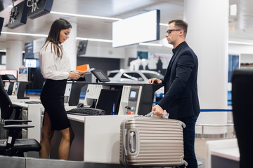 Handsome businessman handing over air ticket at airline check in counter