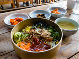 Fototapeta Na drzwi - Traditional Korean bibimbap, a dish of rice, meat and vegetables, served in a hot stone bowl, in the town of Jeonju in South Korea