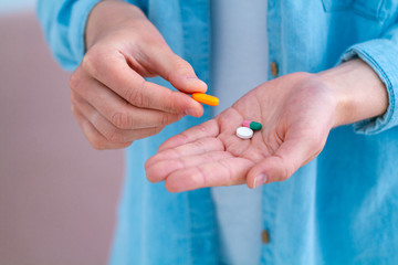 Medicine woman taking pills and vitamins for wellness at home close up. Health care and treatment diseases.