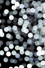 abstract bokeh of white city lights on black background. defocused and blurred many round light