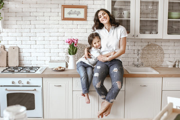 happy mother with daughter in kitchen at home