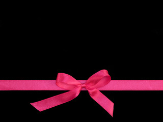 Wall Mural - Bows from pink satin ribbon horizontally on black background with copy space. Greeting card concept