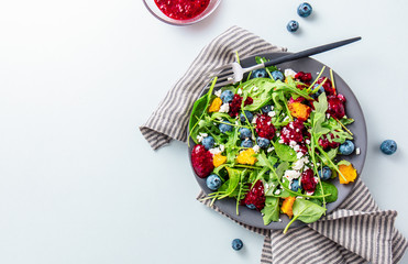 Wall Mural - Summer salad with salad leaves, fruits, berries and cheese