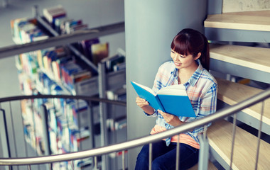 Poster - education, high school, university, learning and people concept - happy smiling asian student girl reading book sitting on stairs at library