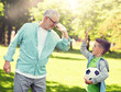 © Syda Productions - family, generation, gesture, sport and people concept - happy grandfather and grandson with football ball making high five at at summer park