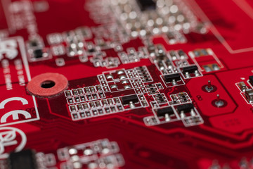 Transistors from the back of the video card under the graphic core. Macro shooting of a red microcircuit.