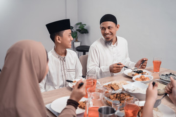 muslim father and son eating some dinner together at home