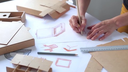 Wall Mural - Designer draws a mockup for crafting cardboard box. Development of packaging design sketch. 