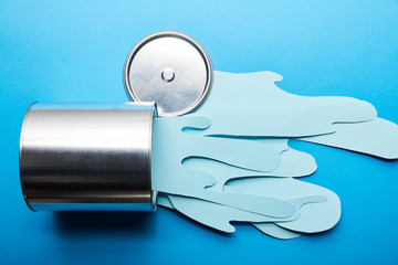 Sticker - top view of spilled paper cut blue paint near silver shiny can and cap