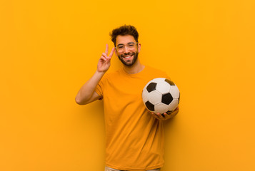 Young soccer player man fun and happy doing a gesture of victory