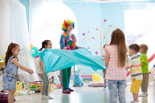 Fotografía Children group have fun on birthday party. Clown entertains kids
