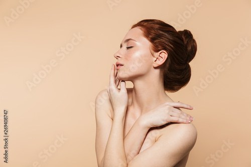 Fotomural Amazing young redhead woman posing isolated over beige wall background