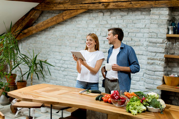 Sticker - Lovely cheerful couple cooking dinner together and having fun at rustic kitchen