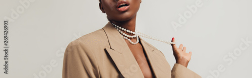 Cuadros en Lienzo cropped view of seductive african american woman in beige jacket and necklace is