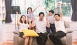 Portrait of Asian multi generation family sit on sofa and cheering in the living room.