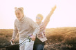 © simona - Happiness for active senior retired people lifestyle concept - joy old aged caucasian couple riding together a bika laughing and smiling a lot and having fun - outdoor leisure activity - sunset