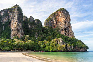 Wall Mural - Landscape of scenic big cliffs on seashore coastline on empty West Railay Beach in the morning in Krabi in Thailand