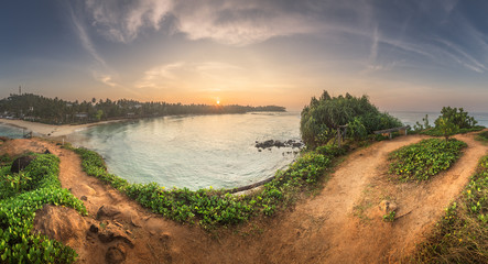 Wall Mural - tropical beach with rocks on sand coast of ocean