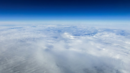 Wall Mural - The beautiful cloudscape with clear blue sky. A view from airplane window.