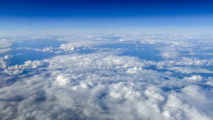 Wall Mural - The beautiful cloudscape with clear blue sky. A view from airplane window.