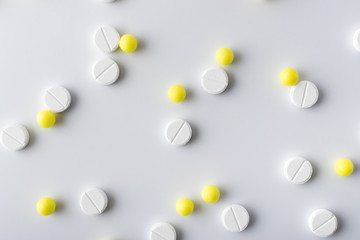 Wall Mural - yellow and white pills of medical drugs and vitamins are in the hospital on a white background.