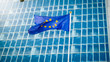 Image of EU flag fluttering on wind against high business office building made of concerete and glass. Concept of ecenomics, development, government and politics