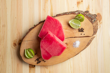 Wall Mural - Fresh raw tuna steak on wooden cutting board, top view.