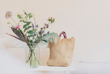Flower Vase And Open Calendar On White Bench, Linen Shopping Bag