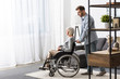 © LIGHTFIELD STUDIOS - full length view of of man carrying disabled mother on wheelchair