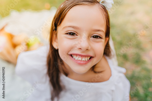 Close Up Portrait Of Dark Eyed Girl With Cheerful Smile Posing