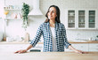 Young beautiful modern woman stands near table on kitchen at home.