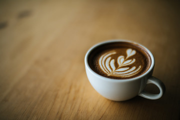 Latte art in coffee cup on the cafe table