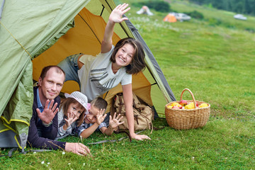 Family Parents and two children in camp tent. Happy Mother, father, son and daughter on Summer vacation