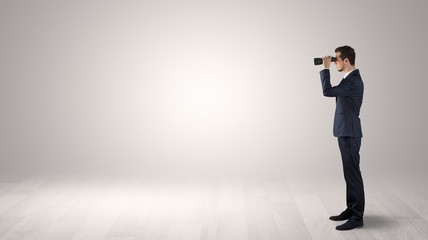 Wall Mural - businessman looking forward with binoculars in an empty space